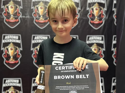 Student with his brown belt and certificate at Astons Kickboxing Academy, Shrewsbury