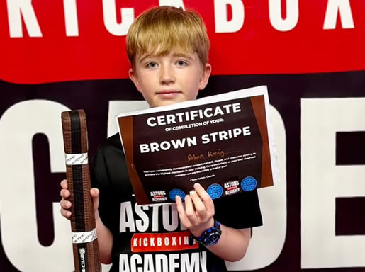 Student with his brown stripe belt and certificate at Astons Kickboxing Academy, Shrewsbury