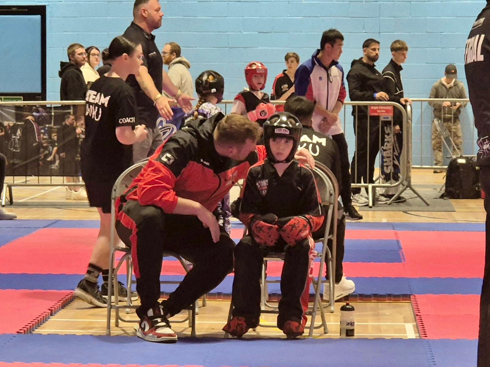 Chris Aston coaching a student ringside at a kickboxing competition