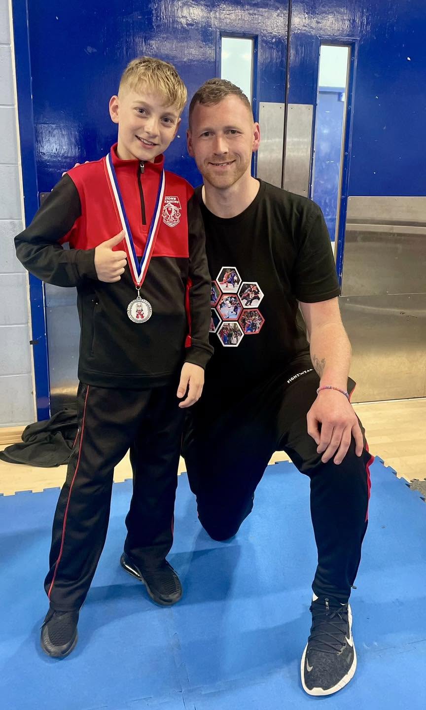 Chris Aston with a young Astons student and his competition medal