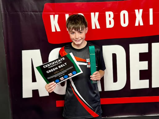 Student with his green belt and certificate at Astons Kickboxing Academy, Shrewsbury