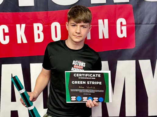 Student with his green stripe belt and certificate at Astons Kickboxing Academy, Shrewsbury