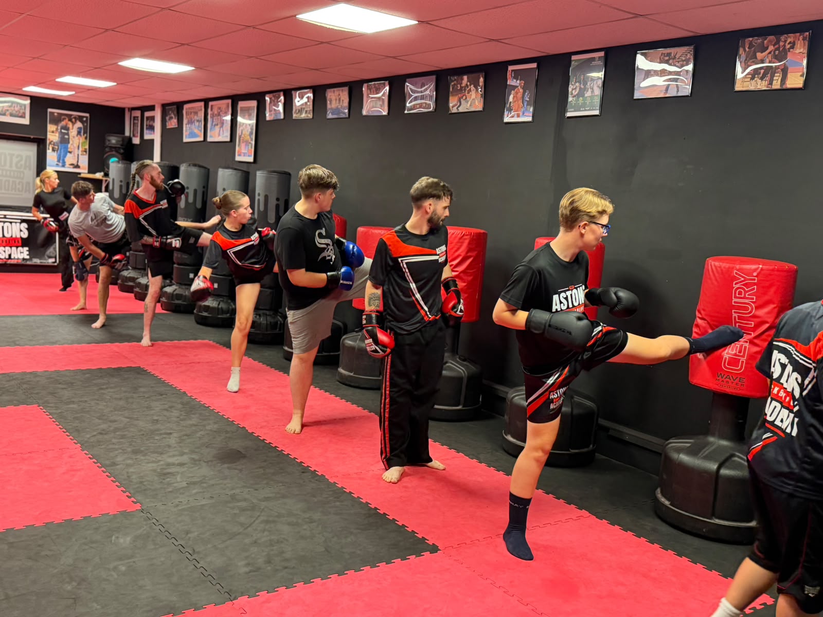 Adults kickboxing class lined up kicking the punching bags at Astons Kickboxing Academy, Shrewsbury