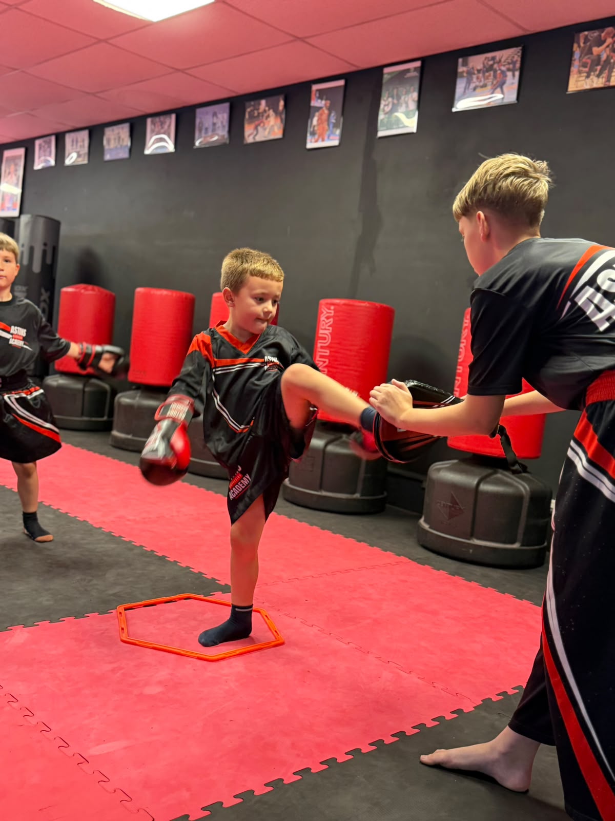 Little Dragons student kicking a pad held by a coach at Astons Kickboxing Academy, Shrewsbury