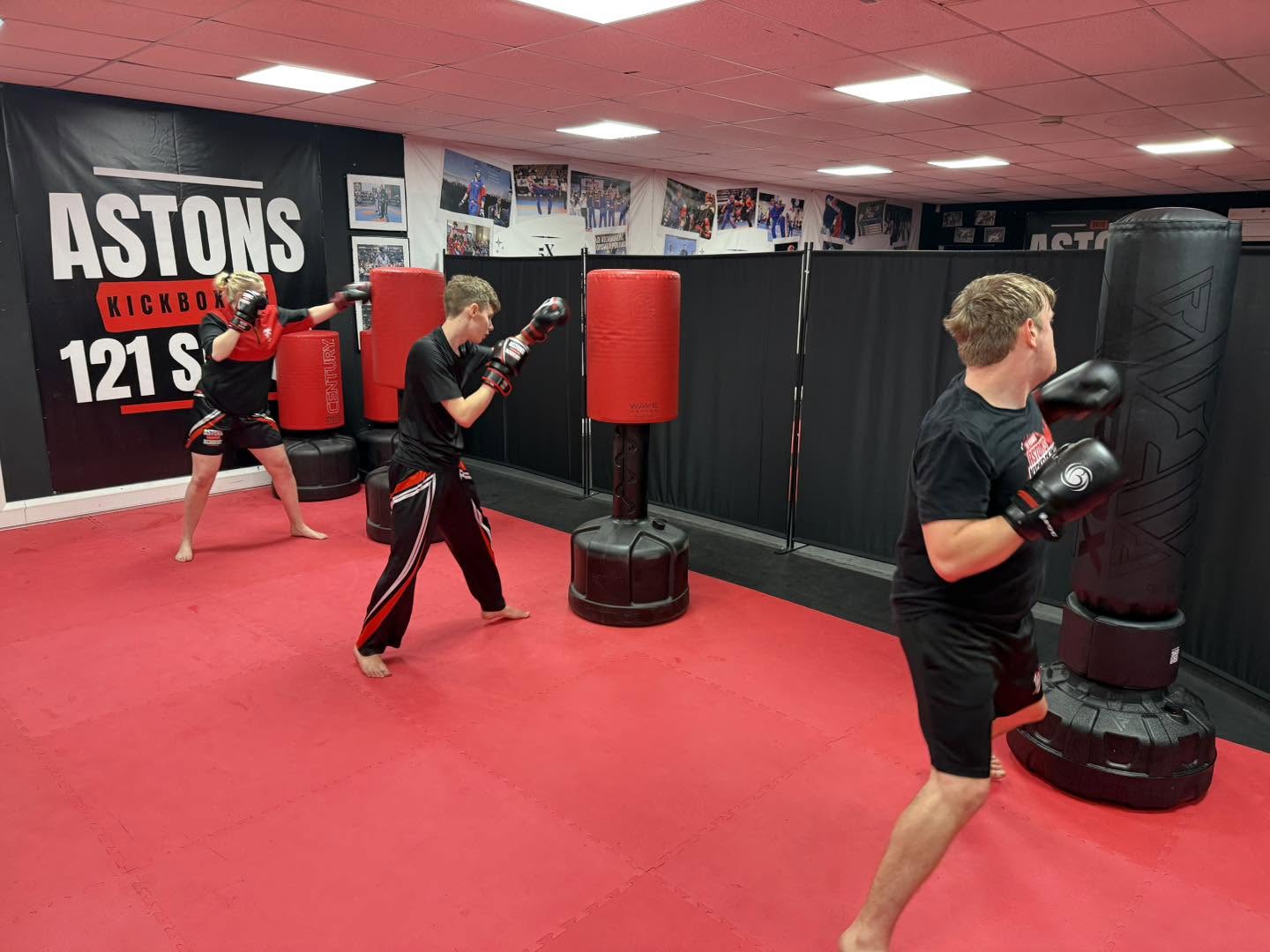 Adults working the punching bags in a Pads and Bags class at Astons Kickboxing Academy, Shrewsbury